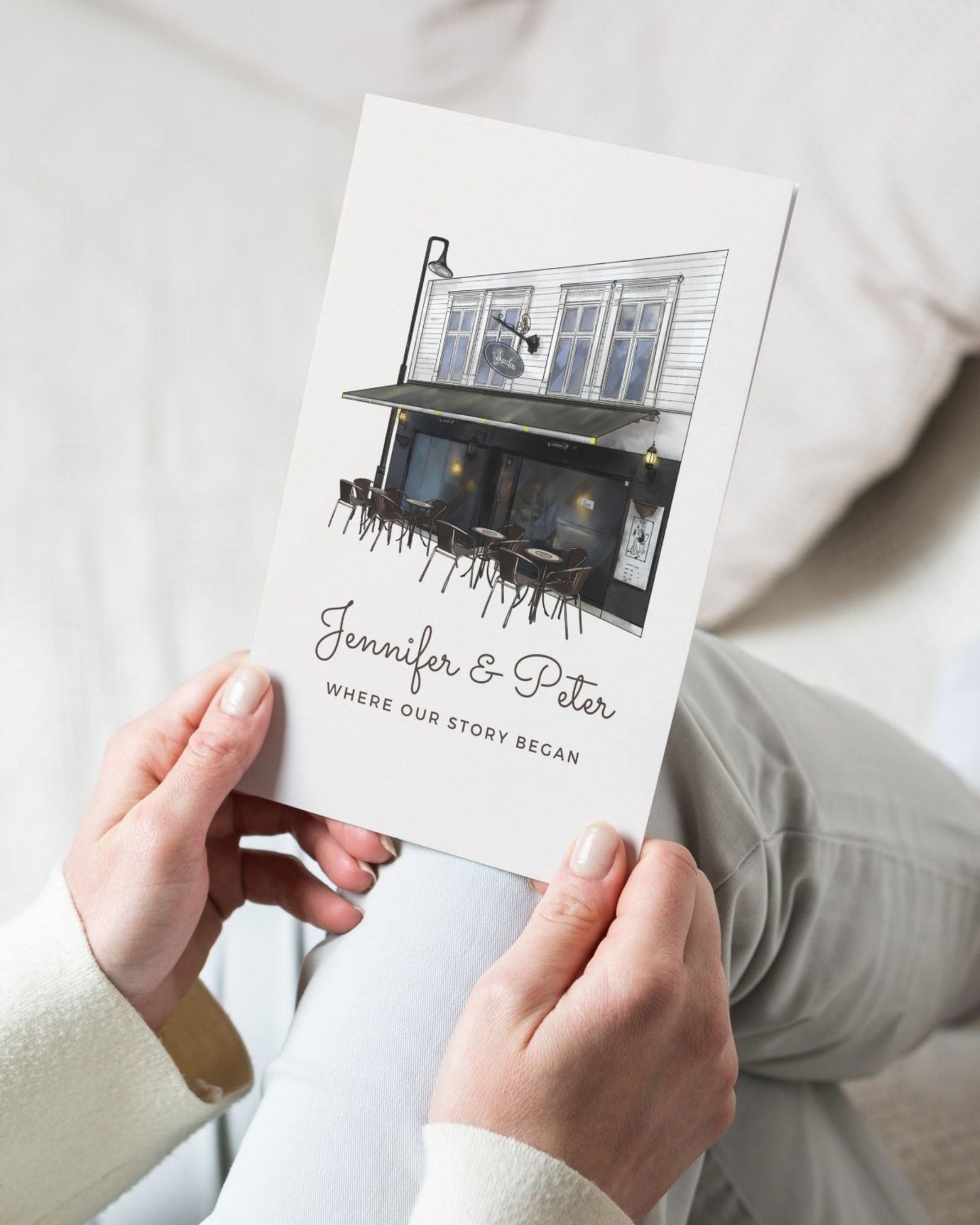 Person holding a card with a house illustration and text on a white background
