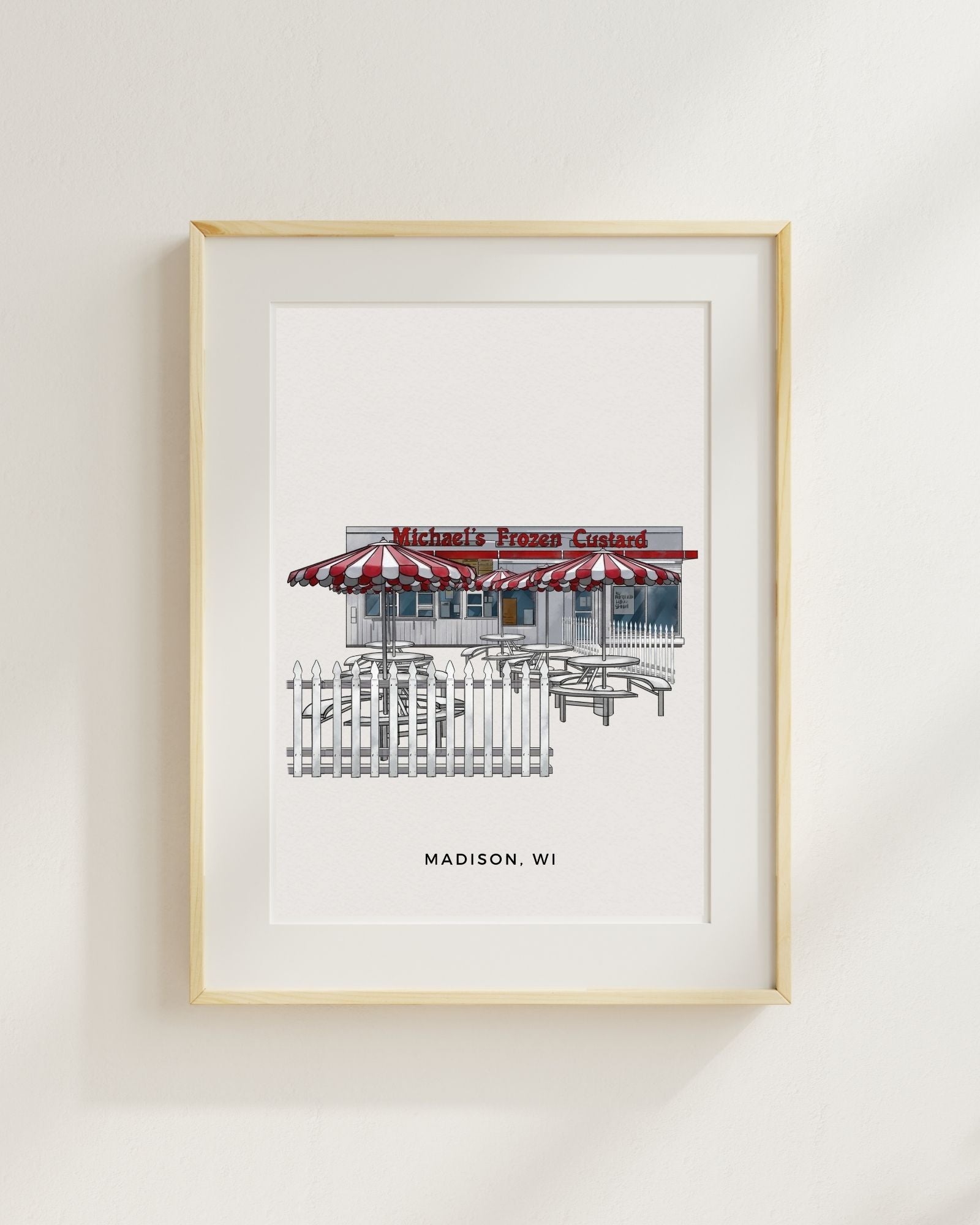 Framed artwork of a frozen custard shop with red and white striped awning on a light gray wall.