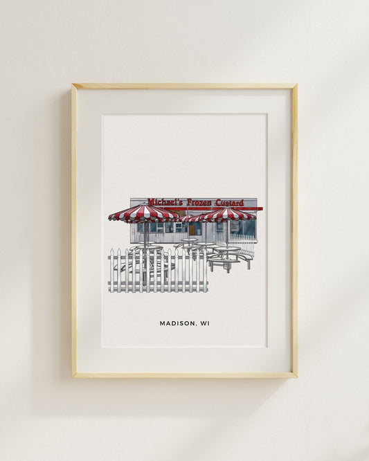 Framed artwork of a frozen custard shop with red and white striped awning on a light gray wall.